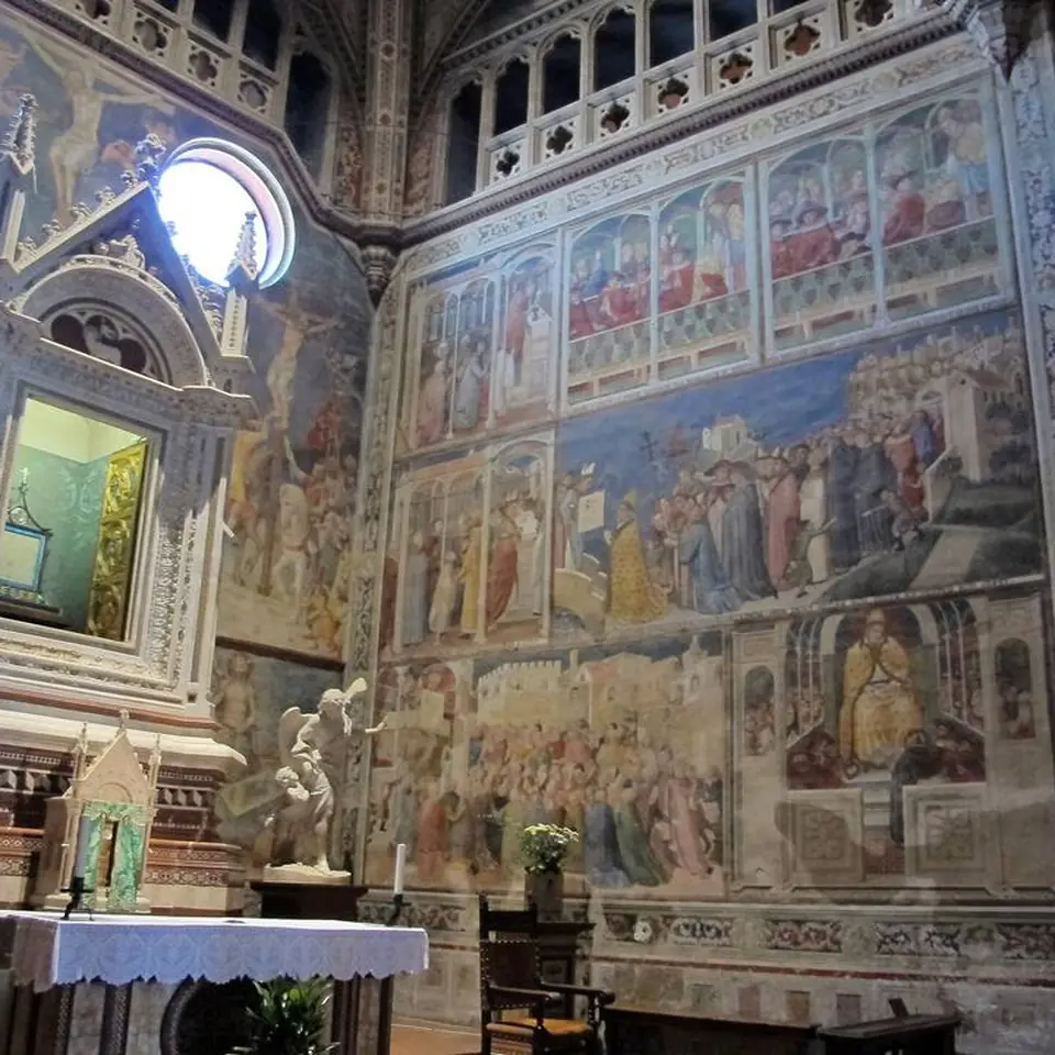 The Chapel of the Corporal in Orvieto Cathedral, its walls filled with fourteenth-century frescoes, the reliquary holding the corporal in the niche at left